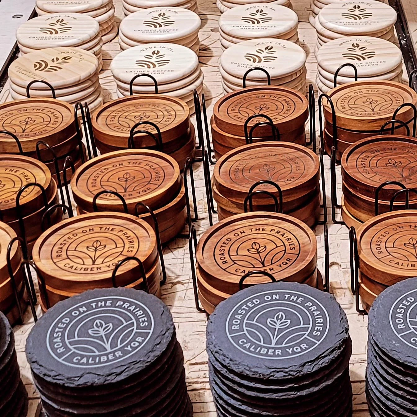 Rows of corporate coasters with engraved designs