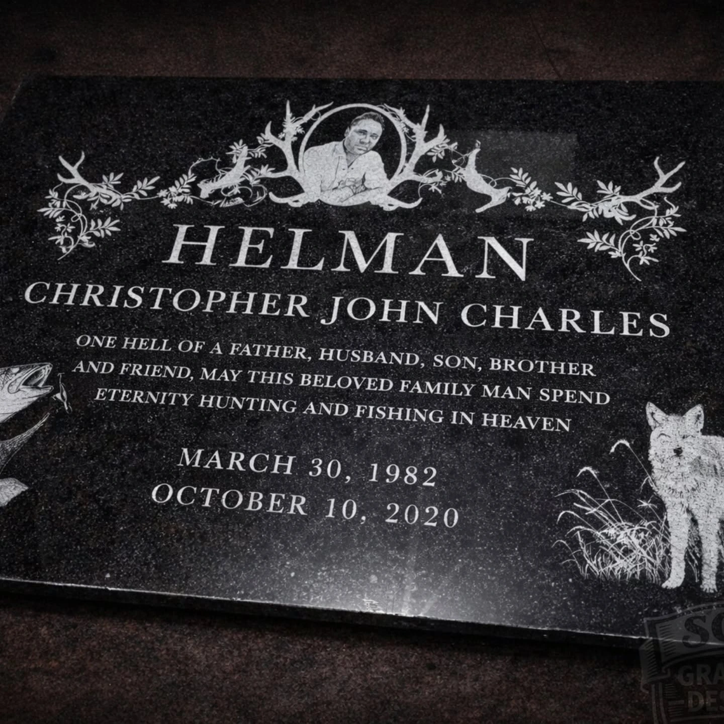 Dark memorial stone engraved with wording and floral details