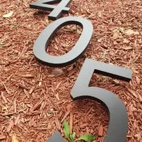Metal address numbers arranged on a garden bed