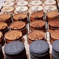 Rows of round corporate coasters with engraved designs