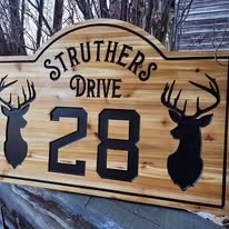 Wood cottage sign with deer silhouettes and address number 28