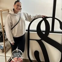 Large dimensional entry sign displayed beside a person