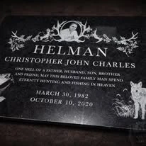 Dark engraved memorial plaque with decorative floral details