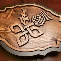 Carved wood pub sign with thistle artwork